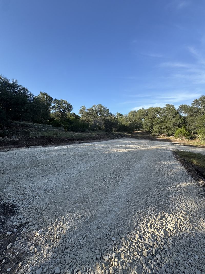 Finished gravel drive cut through hill country